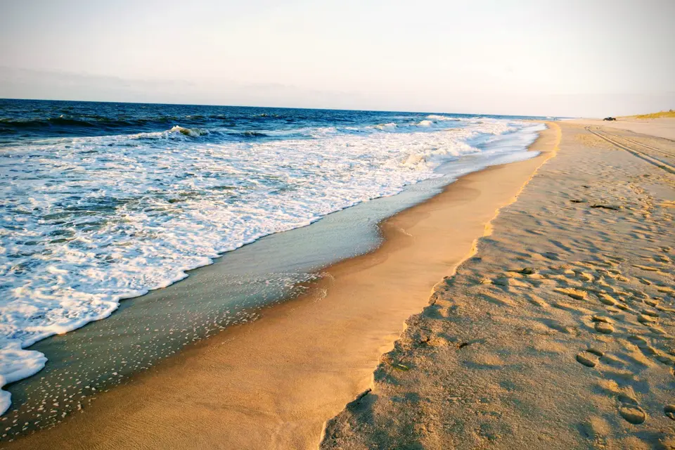 Golden sand, foamy surf and warm low light on Georgica Beach in East Hampton.